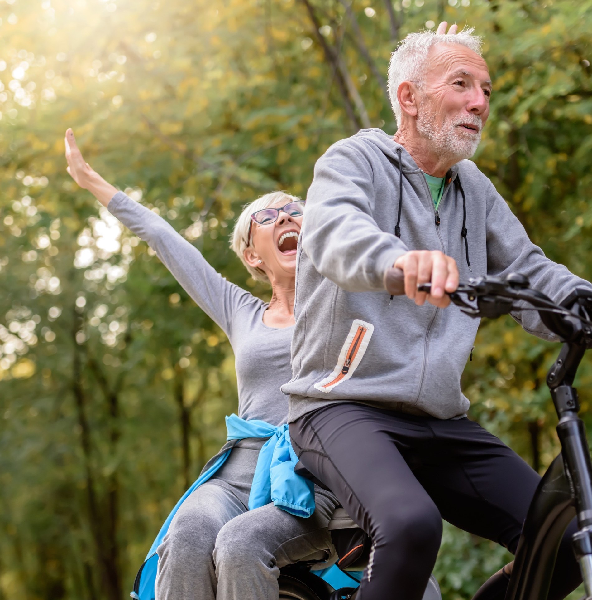 Happy older couple ride a bike together after functional medicine treatment at Heritage Regenerative Medicine